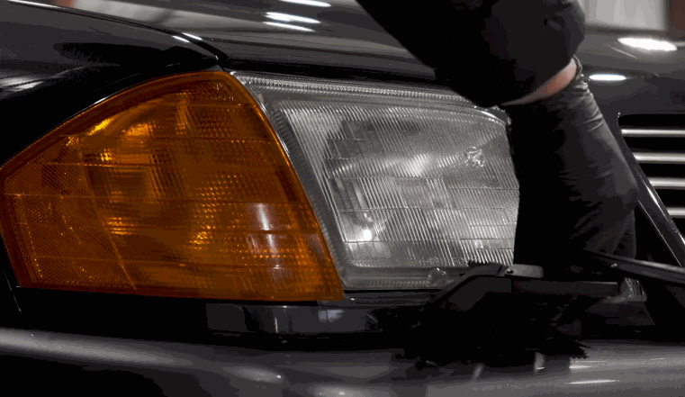 Technician removes the headlight housing of a car to prepare for ceramic coating application.