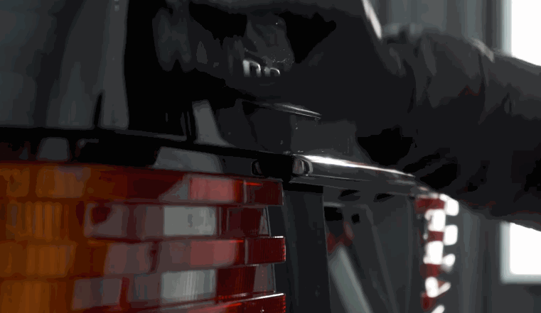 Close-up of a gloved hand opening a car trunk before applying ceramic coating.